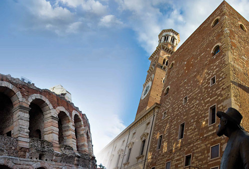 Arcadas del anfiteatro Arena de Verona y Estatua de bronce en la bella Plaza Delle Erbe